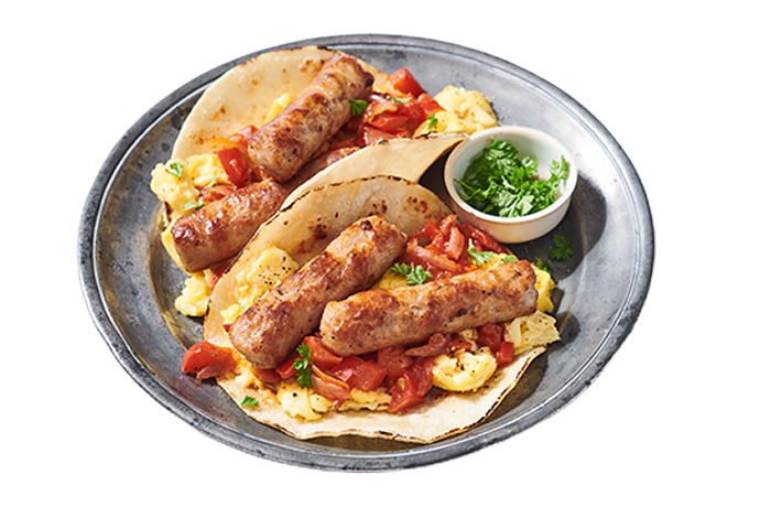 A plate of breakfast tacos with sausage links