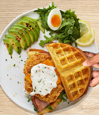 fried chicken breast, a Belgian waffle, a green salad with a soft-boiled egg and lemon wedges