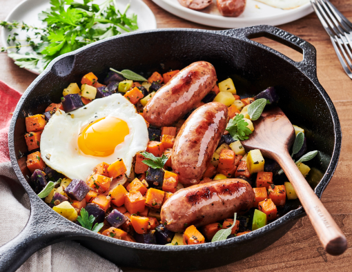 Skillet Apple & Root Vegetable Hash topped with chicken sausage links and fired eggs
