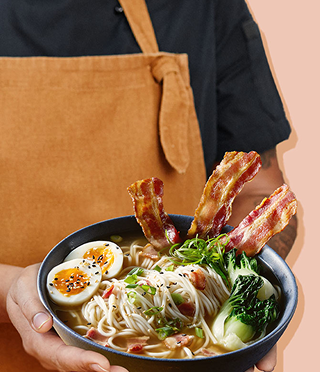 ramen noodles, three slices of crispy bacon, bok choy, broth, and a soft-cooked egg