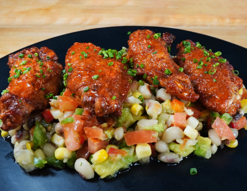Pollo Asada Wings With Cowboy Caviar on a black plate