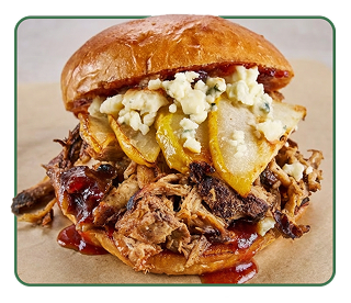 A pork barbecue sandwich stuffed with cooked pear slices and blue cheese crumbles