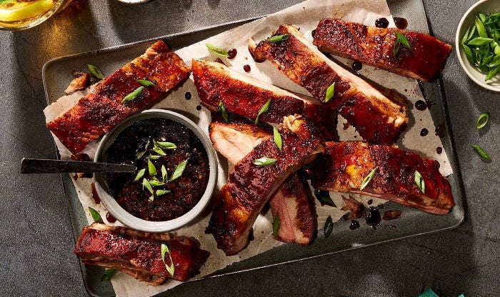 Tender pork ribs with pomegranate molasses glaze, topped with pomegranate seeds and fresh scallions