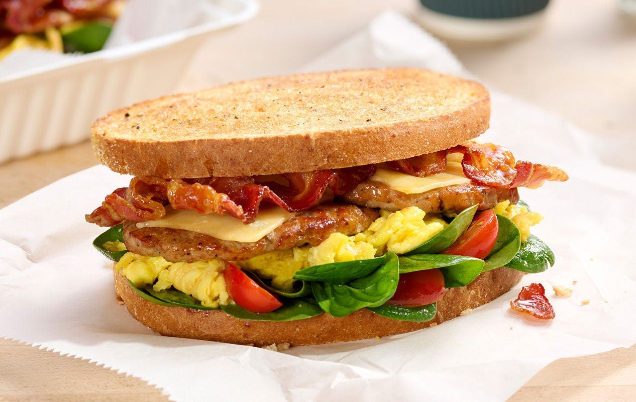 Brunchhouse Breakfast Sandwich Recipe bacon, pork sausage, scrambled egg, smoked Gouda with grape tomatoes and baby spinach