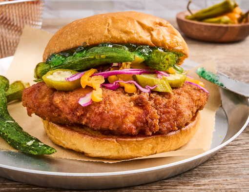 Southern Heat Breaded Chicken Sandwich on a metal plate with a side of fries