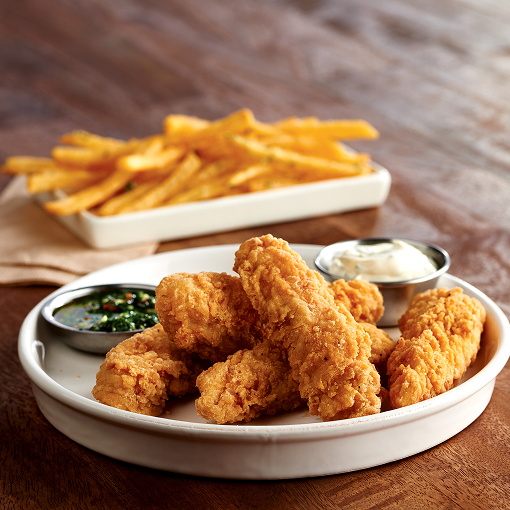 Crispy breaded chicken tenderloin fritters with dipping sauce, perfect for appetizers or snacks
