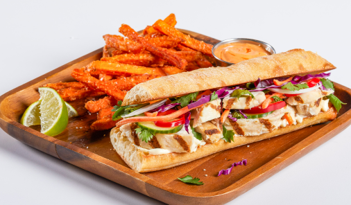 Baguette sandwich with grilled chicken breast strips, shredded carrot, cucumber, red onion and cilantro