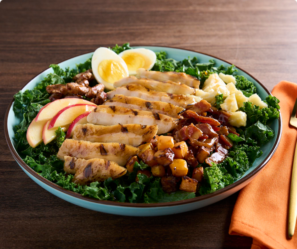 Chicken Maple Bacon Chop Salad topped with walnuts, hard boiled egg, apples and fresh kale