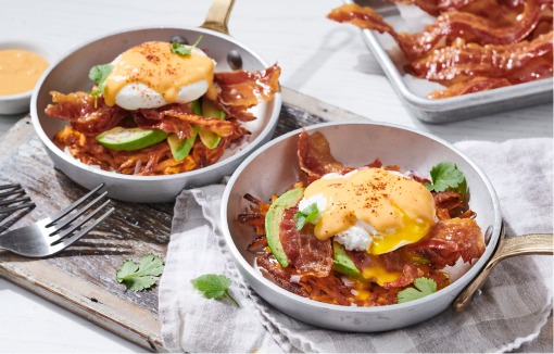 Breakfast bowls with bacon, avocado, egg and garnishes.