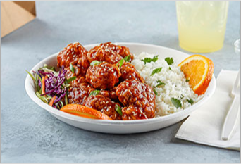 Asian rice bowl with teriyaki breaded chicken, oranges and slaw on the side