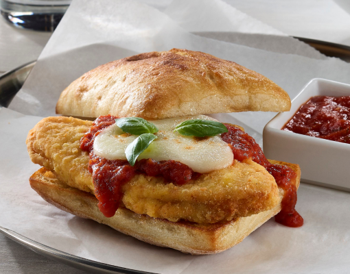 A juicy chicken sandwich covered in cheese and marinara sauce