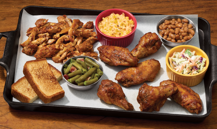 Large platter of smoked chicken wings and pulled chicken with mac and cheese, baked beans, coleslaw, green beans, and toasted bread