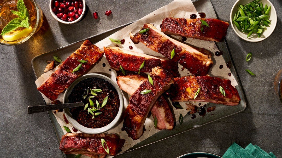 Ribs on a metal tray with BBQ sauce