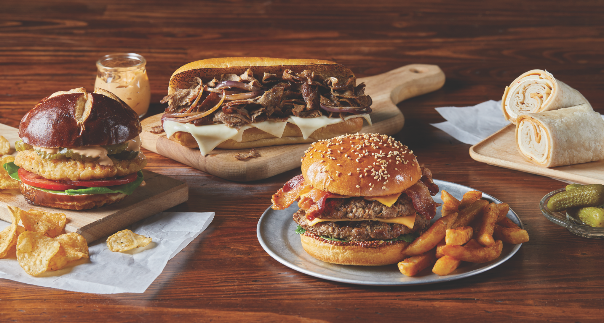 Chicken sandwich on Brioche, Beef Burger with fries, philly steak sandwich and a wrap