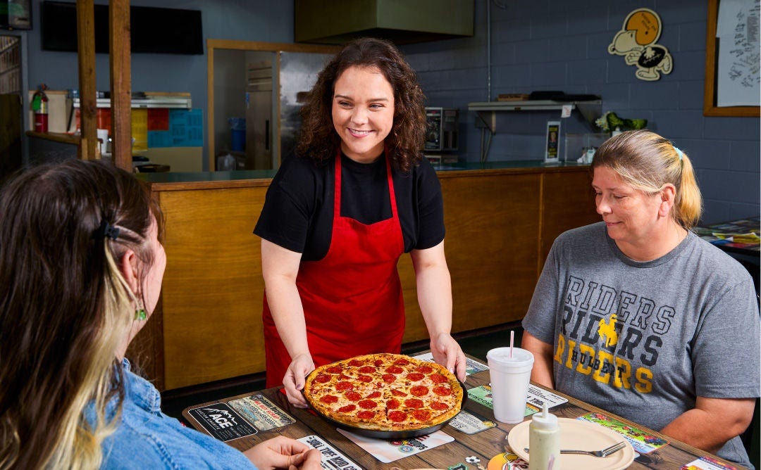 2024 Great Pizza Give Back Winner Abigail Manes from MVP Pizza serving a pizza to customers