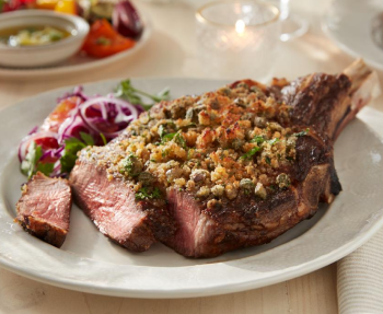 Plated beef steak strips, topped with cheese crumbles and a side salad 