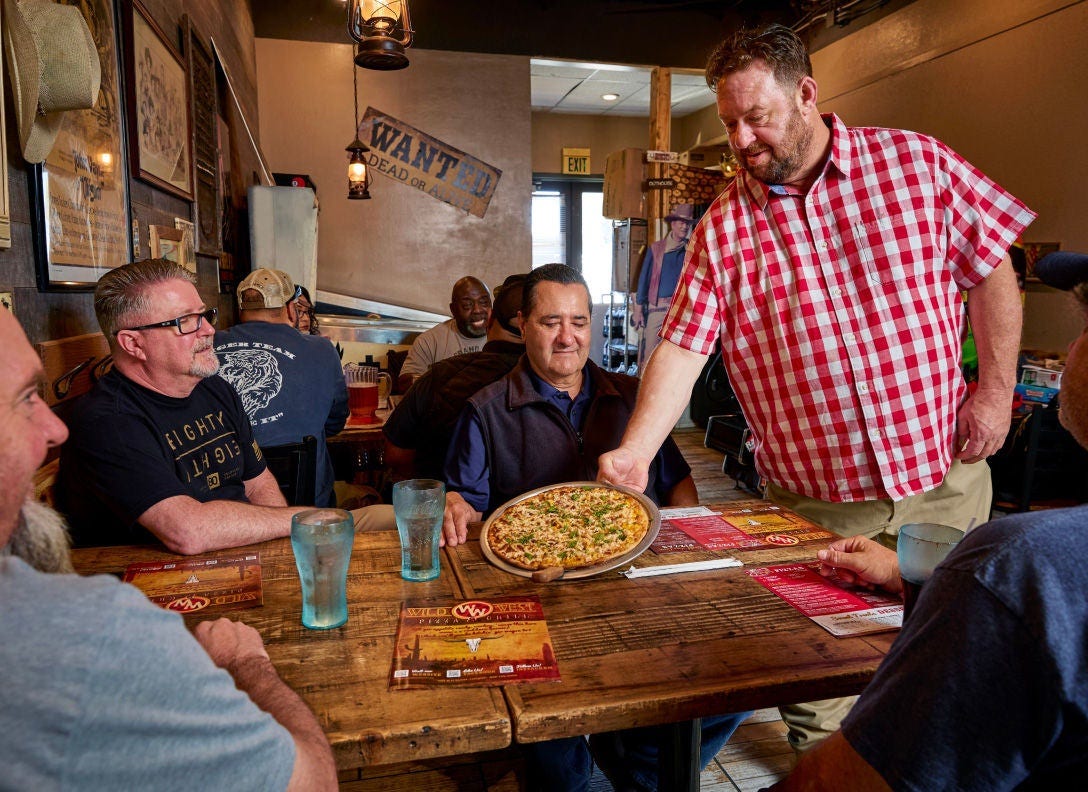 2025 Great Pizza Give Back Winner David Goldy from Wild West Pizza serving a pizza to customers