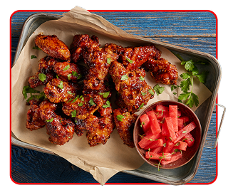 crispy chicken wings with a ramekin of chilled watermelon