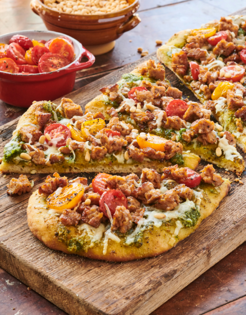Pesto Flatbread Pizza featuring Hillshire Farm® All Natural* Fully Cooked Italian Sausage on cutting board