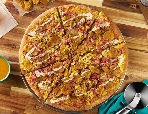 pizza crust topped with golden BBQ sauce, smoked mozzarella cheese, loads of crispy pizza topping, corn kernels and fried pickles