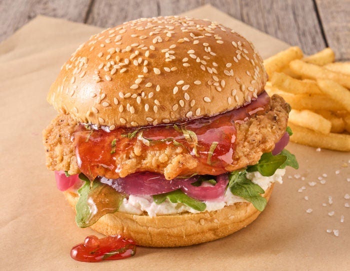 Chicken Sandwich featuring straberry jam, basil, and sauce with a side of fries