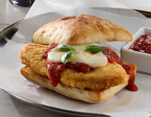 Chicken breast pattie with marinara sauce, mozzarella cheese and basil leaves on ciabatta bread