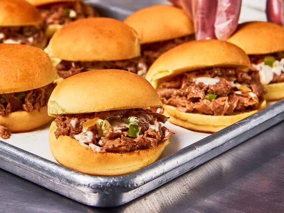 Eight chessesteak sliders on a alluminum platter