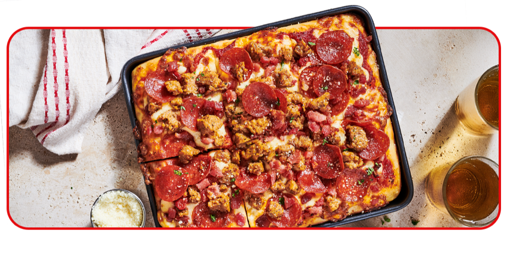 Overhead shot of pizza and side of wings on table setting